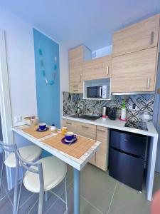 a kitchen with a table and chairs and a counter top at Gloria Maris Apartment in Menton +10 photos