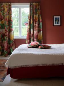 uma cama num quarto com uma janela com cortinas em Sikfors Herrgård em Hällefors