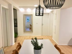 a dining room with a white table and a mirror at Villa Sol Necujam - private pool and 30m from the beach in Nečujam