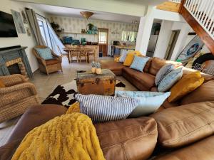 uma sala de estar com mobiliário de couro castanho e uma mesa em Buff and Fellow by the Bay em Groot Brak Rivier