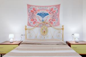 Schlafzimmer mit einem Bett mit Wandgemälde in der Unterkunft Appartamento Caterina in Siniscola