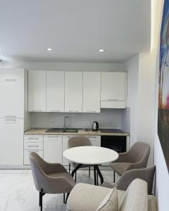 a kitchen with a white table and chairs in a room at NÓS apartment 1 in Shkodër