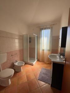 a bathroom with a toilet and a sink and a shower at Domus de Goene in Loceri