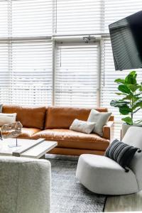 a living room with a brown couch and a table at 5 Points Retreat in East Nashville Walk to Restaurants Bars and Music in Nashville