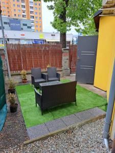 a patio with two chairs and a table on green grass at Apartmán pri Sokolovni in Martin