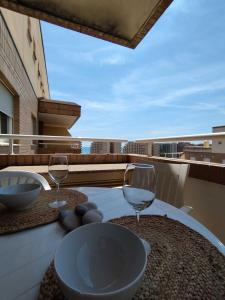 a table with two wine glasses on a balcony at Costa Caribe III Nº 1108 in Oropesa del Mar