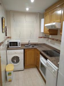 a small kitchen with a sink and a microwave at Costa Caribe III Nº 1108 in Oropesa del Mar