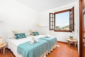 1 dormitorio con 2 camas y ventana en Sunset Tirant, en Fornells