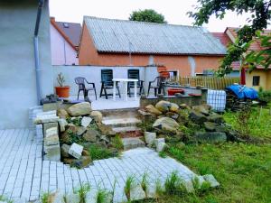 a backyard with a stone wall and a table and chairs at Ferienwohnung Am Himmel in Birx