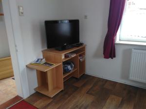 a television on a stand in a room at Ferienwohnung Am Himmel in Birx