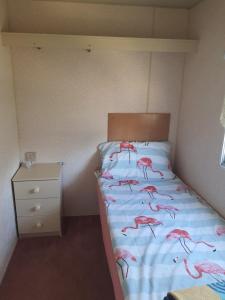 ein Schlafzimmer mit einem Bett mit rosa Flamingos darauf in der Unterkunft Wieczorne Mgły in Borsk