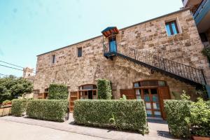 an old stone building with bushes in front of it at Old Town Guesthouses-Batroun in Batroûn