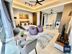 a living room with a bed and a living room with a tv at Grand Medini Residence @ UHA in Nusajaya