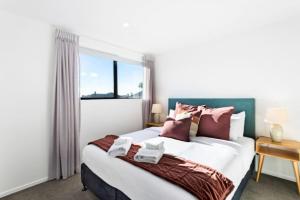 1 dormitorio con 1 cama grande y ventana en Stunning New 2BR Luxury in Pukekohe - WiFi Netflix en Pukekohe East