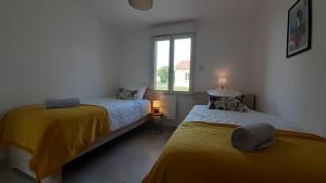 1 dormitorio con 2 camas y ventana en La Bucolique en Simandre