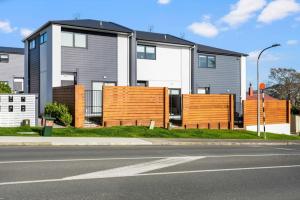 a house with a fence in front of a street at Stunning New 2BR Luxury in Pukekohe - WiFi Netflix in Pukekohe East