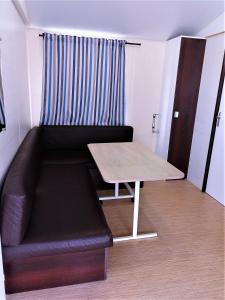 ein Wohnzimmer mit einem Sofa und einem Tisch in der Unterkunft Camping Derby Loredo in Loredo