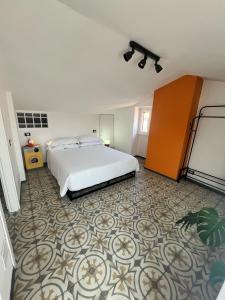 Schlafzimmer mit einem weißen Bett und Fliesenboden in der Unterkunft La casa di Nonna Patti e Andy in Gardone Riviera