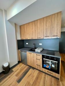 a kitchen with wooden cabinets and a sink and a stove at Sea & Sky Apartments in Budva