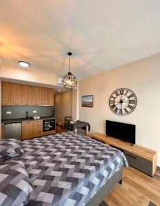 a bedroom with a large bed and a clock on the wall at Sea & Sky Apartments in Budva