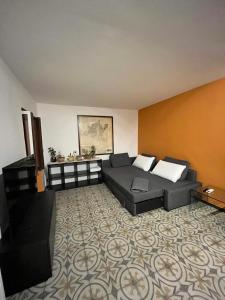 ein Wohnzimmer mit einem Sofa und einem Tisch in der Unterkunft La casa di Nonna Patti e Andy in Gardone Riviera