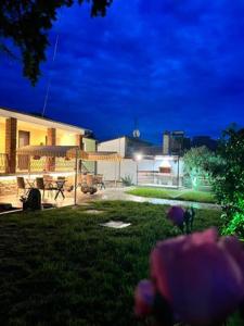 a backyard of a house at night with purple flowers at VILA MARIALENA 