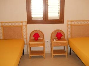トッレ・パリにあるSalentomipiaciのベッド2台とテーブル2台(赤いランプ付)が備わるお部屋