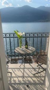 a table with a vase of flowers on a balcony at Celia’s House in Lezzeno