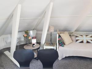 a room with a bed and two chairs and a table at Deluxe STUDIO-appartement Heemstede Zandvoort in Heemstede