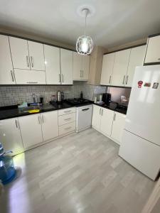 a kitchen with white cabinets and a white refrigerator at gezginin odası in İzmir