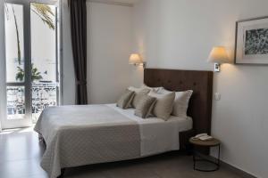 ein Schlafzimmer mit einem Bett mit Kissen und einem Fenster in der Unterkunft Liberty Palace in Milazzo