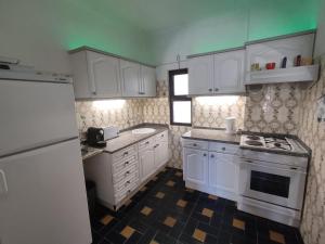a kitchen with white cabinets and a white refrigerator at 6 Mourisca - Casas & Papéis in Lagoa