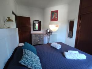 ein Schlafzimmer mit einem blauen Bett mit zwei Kissen in der Unterkunft 6 Mourisca - Casas & Papéis in Lagoa