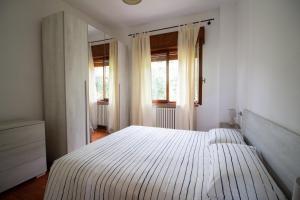 een slaapkamer met een groot wit bed en ramen bij Villa Diana - Appartamenti vista Lago in Brenzone sul Garda