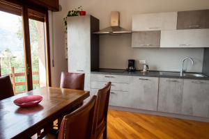 een keuken met een houten tafel en een houten vloer bij Villa Diana - Appartamenti vista Lago in Brenzone sul Garda