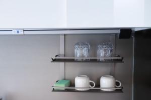 un estante con vasos y tazas en una cocina en Shine residence, en Incheon