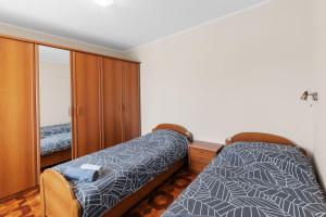 a bedroom with two beds and a cabinet at Apartment Luma in Vižinada