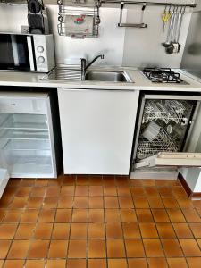 een keuken met een wastafel en een open vaatwasser bij Casa Sabaudia in Turijn