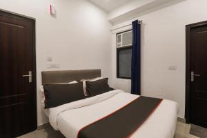 a bedroom with a bed with black and white at Insight Inn Near Gomti Riverfront Park in Vibhuti Khand