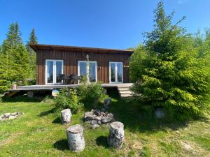 una cabaña de madera con un jardín frente a ella en Cozy forest cabin with amazing mountain view en Torsby