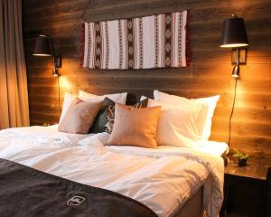 Schlafzimmer mit einem Bett mit weißer Bettwäsche und Kissen in der Unterkunft Ski Lodge Tänndalen in Tänndalen