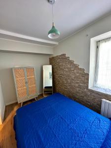 a bedroom with a blue bed and a brick wall at Casa Sabaudia in Turin
