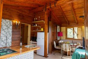 una cucina e una sala da pranzo in una baita di tronchi di CHALET TRA GLI ULIVI: • giardino • WiFi • A/C • bbq a Capri Leone