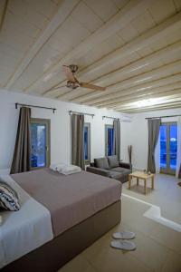 a bedroom with a bed and a living room with a couch at Villabellum Mykonos in Mikonos