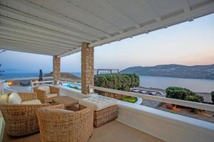 a balcony with wicker chairs and a view of the ocean at Villabellum Mykonos in Mýkonos City