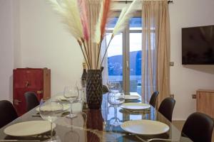 a dining room with a table with wine glasses on it at Villabellum Mykonos in Mýkonos City