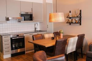 uma cozinha com uma mesa e cadeiras de madeira e uma cozinha com um fogão em Ski Lodge Tänndalen em Tänndalen