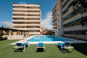 basen z 2 leżakami i budynek w obiekcie Sea view apartment in the center of puerto Banús and private parking w Marbelli