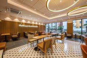a restaurant with tables and chairs and windows at Masan Daisy Hotel in Changwon