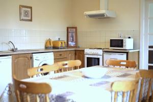 a kitchen with a table and chairs and a kitchen with a table and a kitchen at Long Quay Apartments, Clonakilty in Clonakilty